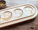 Close-up of full moon phase etchings in wood mala design board.