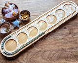 Solid wood mala design board featuring moon phase design etchings in bead compartments.