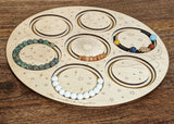 Wooden beading board featuring pre-measured channels to design 7 bracelets at a time.