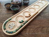 African turquoise and sandalwood beads are being used to design a mala on wood beading board.