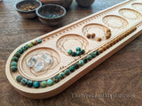 Solid wood mala design board with a half-finished necklace being measured in the beading channel.